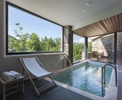 Piscina cubierta con hidroterapia y vistas al exterior del spa del hotel.