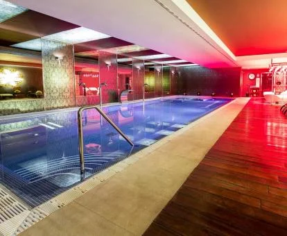 Piscina cubierta con iluminación y elementos de hidroterapia del spa.
