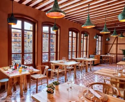 Precioso comedor con amplias ventanas y vistas a la ciudad de este hotel con encanto.