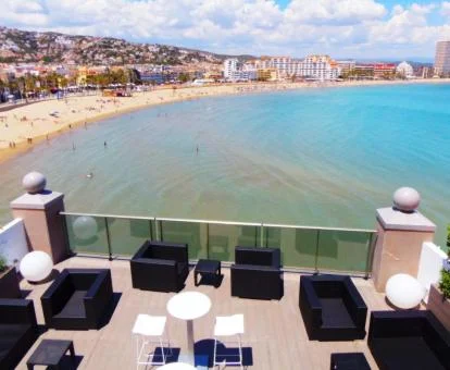 Terraza con mobiliario exterior y vistas al mar y a la ciudad del hotel.