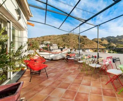 Agradable terraza con mobiliario y vistas a las montaás de este acogedor hotel.