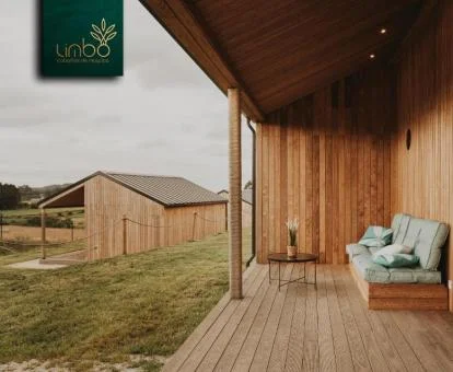 Terraza con vistas al exterior y mobiliario de una de las cabañas de este acogedor complejo rural.