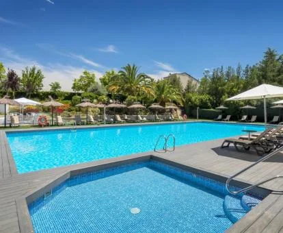 Piscinas exteriores rodeadas de vegetación de este hotel romántico.