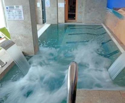 Piscina cubierta con elementos de hidroterapia del spa del hotel.