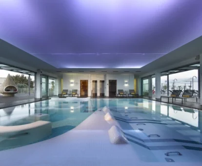 Piscina cubierta con hidroterapia y vistas al exterior del centro de bienestar del hotel.