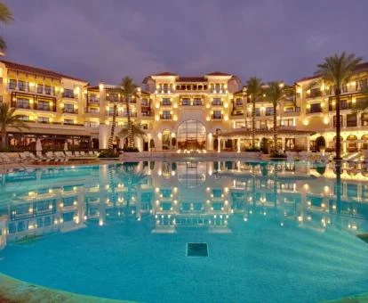 Fabuloso hotel con gran piscina exterior rodeada de tumbonas.