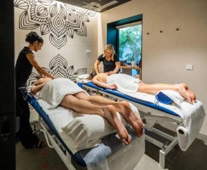 Pareja disfrutando de un tratamiento en la sala de masajes del spa.