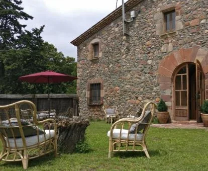 Fachada de piedra de este precioso hotel rural con comedores en el jardín.