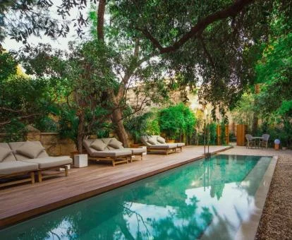 Preciosa piscina rodeada de tumbonas y bellos jardines.