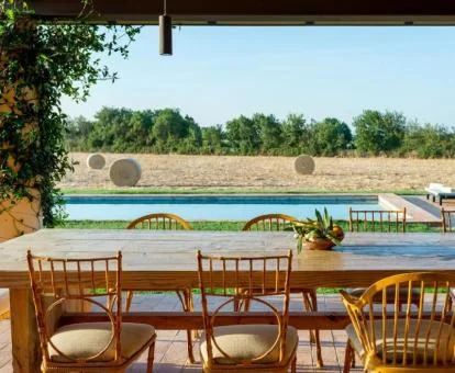 Terraza con mobiliario y vistas a la piscina y a los alrededores de este precioso hotel rural.