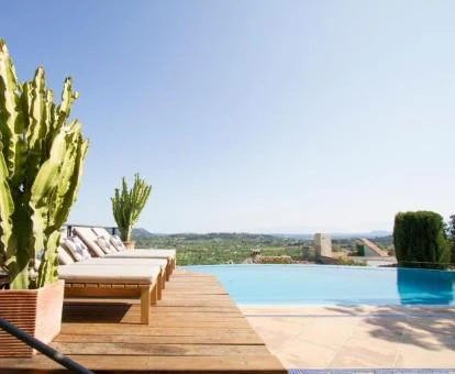 Terraza solarium con piscina y vistas a la naturaleza.