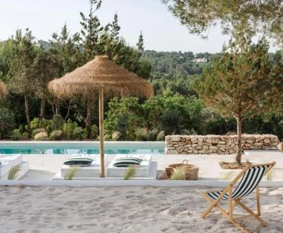 Agradable piscina exterior con vistas a la naturaleza y solarium del hotel.