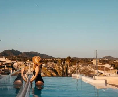 Piscina exterior con borde infinito y preciosas vistas el hotel.