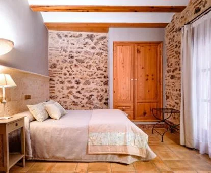Una de las coquetas habitaciones con paredes de piedra a la vista de este hotel rural.
