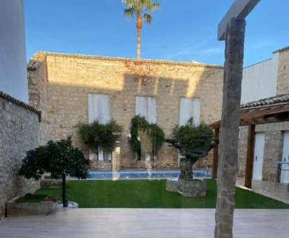 Patio con jardín y piscina exterior de este hotel con encanto.
