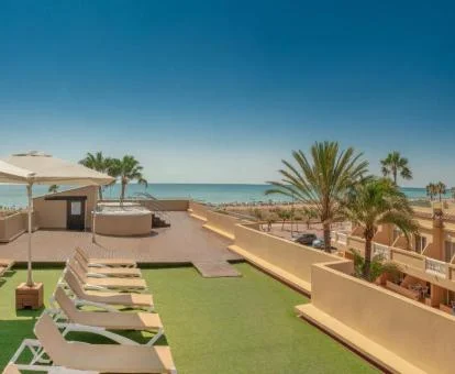 Agradable terraza solarium con jacuzzi exterior y vistas al mar de este moderno hotel.