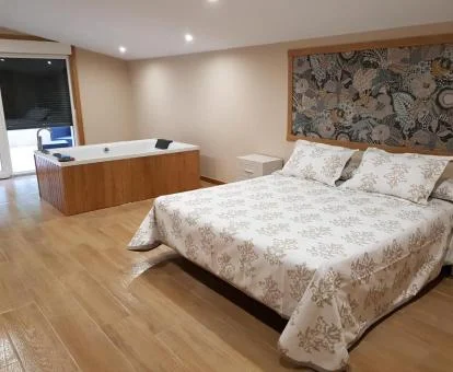 Dormitorio del apartamento deluxe con bañera de hidromasaje privada junto a la cama.