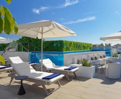 Terraza solarium con mobiliario y piscina al aire libre del hotel.