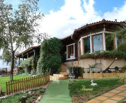 Edificio de este hotel rural rodeado de jardines con amplios ventanales.