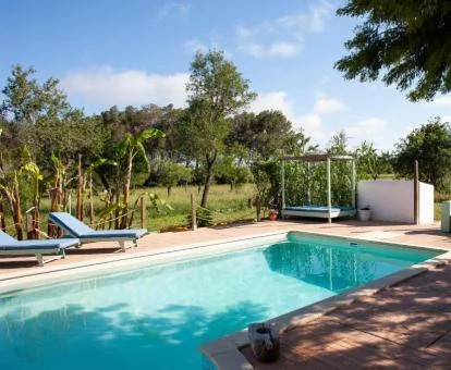 Acogedora piscina rodeada de espacios verdes con tumbonas de este hotel rural.