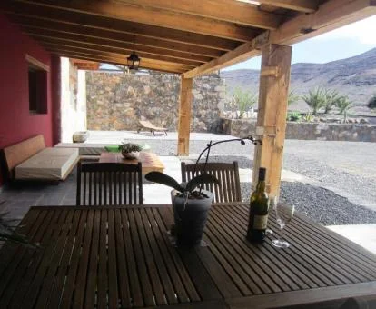 Porche con mobiliario y vistas al campo que rodea esta casa rural independiente.