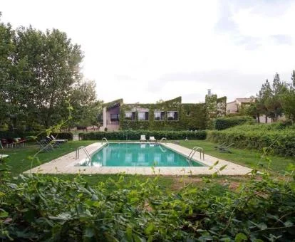 Hotel con encanto con grandes jardines y piscina exterior.