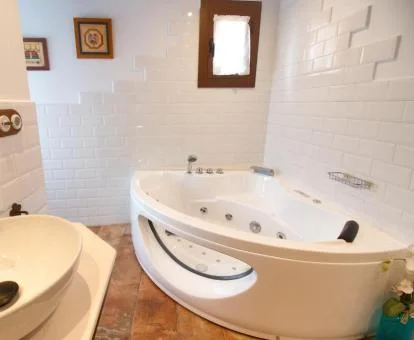 Baño con un amplio jacuzzi privado de este bonito apartamento con vistas a las montañas.