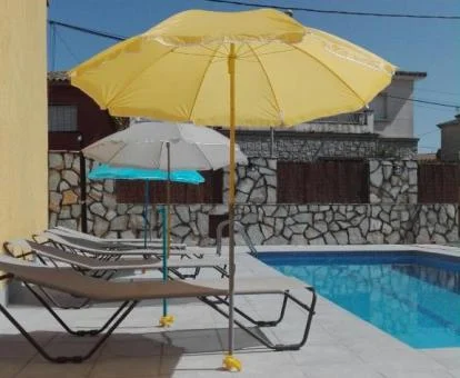 Zona exterior con piscina y tumbonas de este alojamiento rural.