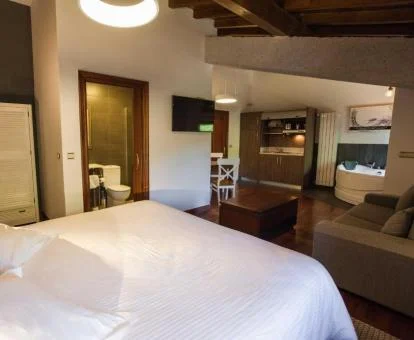Habitación con cama extragrande, cocina y jacuzzi privado de este establecimiento.