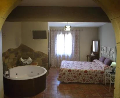 Dormitorio con bañera de hidromasaje de uno de los apartamentos del establecimiento.