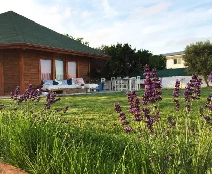 Coqueta casa de madera con amplios jardines privados y zona exterior amueblada.