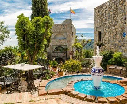 Exteriores de este bello hotel boutique en un castillo con jardín y mobiliario.