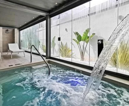Zona de aguas con chorros y vistas al exterior del spa del hotel.
