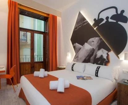 Moderna habitación doble decorada con tonos anaranjados de este hotel solo para adultos.