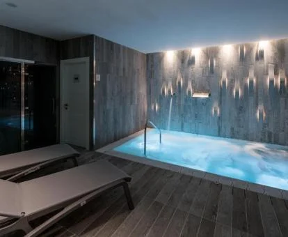Acogedora sala del centro de spa del hotel con tumbonas y piscina de hidroterapia.