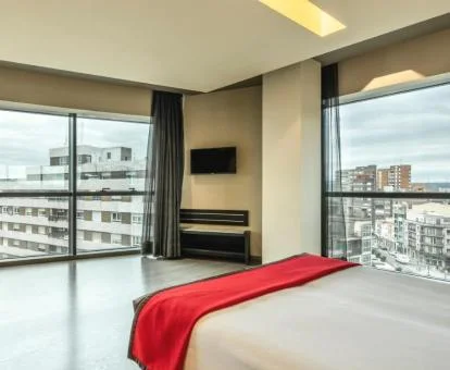Una de las amplias habitaciones con grandes ventanales y vistas a la ciudad de este moderno hotel.