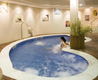 Mujer disfrutando de la zona de aguas del centro de spa del hotel.