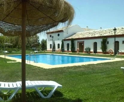 Establecimiento rural con amplios jardines y piscina al aire libre.