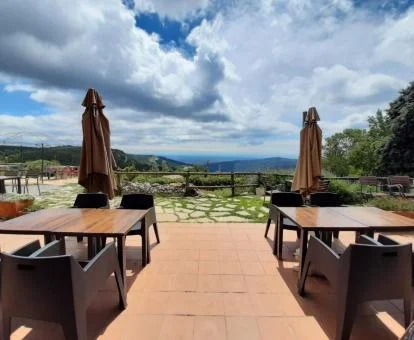 Terraza con espectaculares vistas a las montañas y comedores exteriores de este hotel rural.