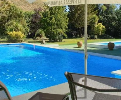 Zona exterior con piscinas y amplios jardines de este alojamiento rural.