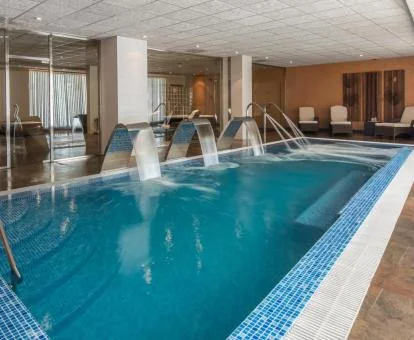 Piscina cubierta con elementos de hidroterapia del spa del hotel.