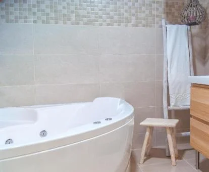 Baño con bañera de hidromasaje privada del apartamento de dos dormitorios de este establecimiento.
