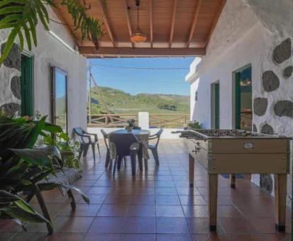 Terraza cubierta con mobiliario y vistas al campo de esta casa rural independiente.