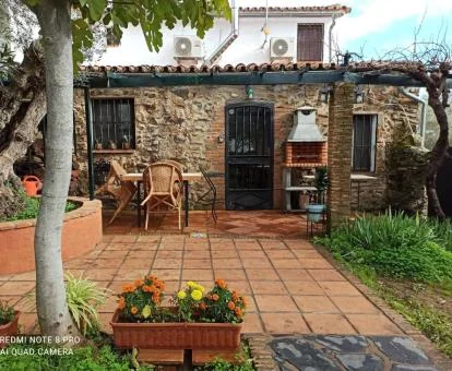 Agradable zona exterior con jardín y mobiliario de esta casa independiente.