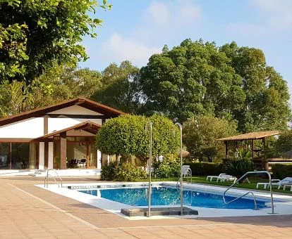 Hermoso hotel rodeado de vegetación con piscina exterior.
