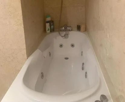 Bañera de hidromasaje privada en el baño de este apartamento.