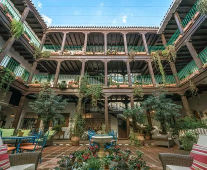 Precioso hotel con patio interior y mobiliario al aire libre.