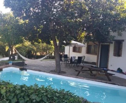 Zona exterior con piscina rodeada de naturaleza de esta casa independiente.