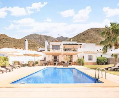 Precioso cortijo con zonas exteriores y piscina rodeado de montañas.