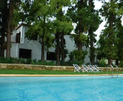 Hotel rural con amplios jardines y piscina exterior.